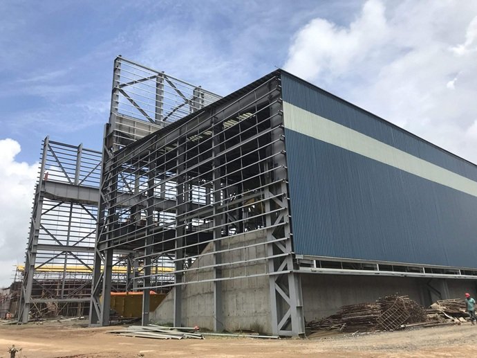 Fase de montaje exterior de paneles sándwich sobre estructura metálica por técnicos expertos.