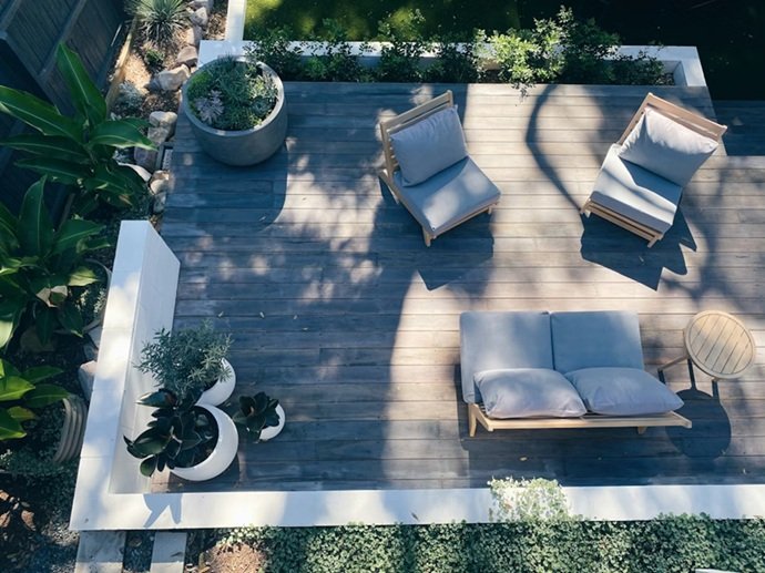 Vista aérea de habitáculo exterior de madera tratada para jardín mediterráneo.